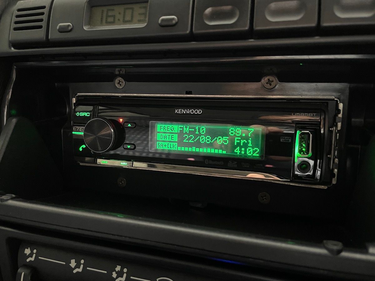 装着されていたケンウッド製のCDレシーバーはイルミネーション・カラーを自由に選択できるので、メーター色に合わせて緑に設定しているが、やはり派手だ。普段は開閉式のフタを閉じている。写真はカークラフトによって配線を修正した後の状態。