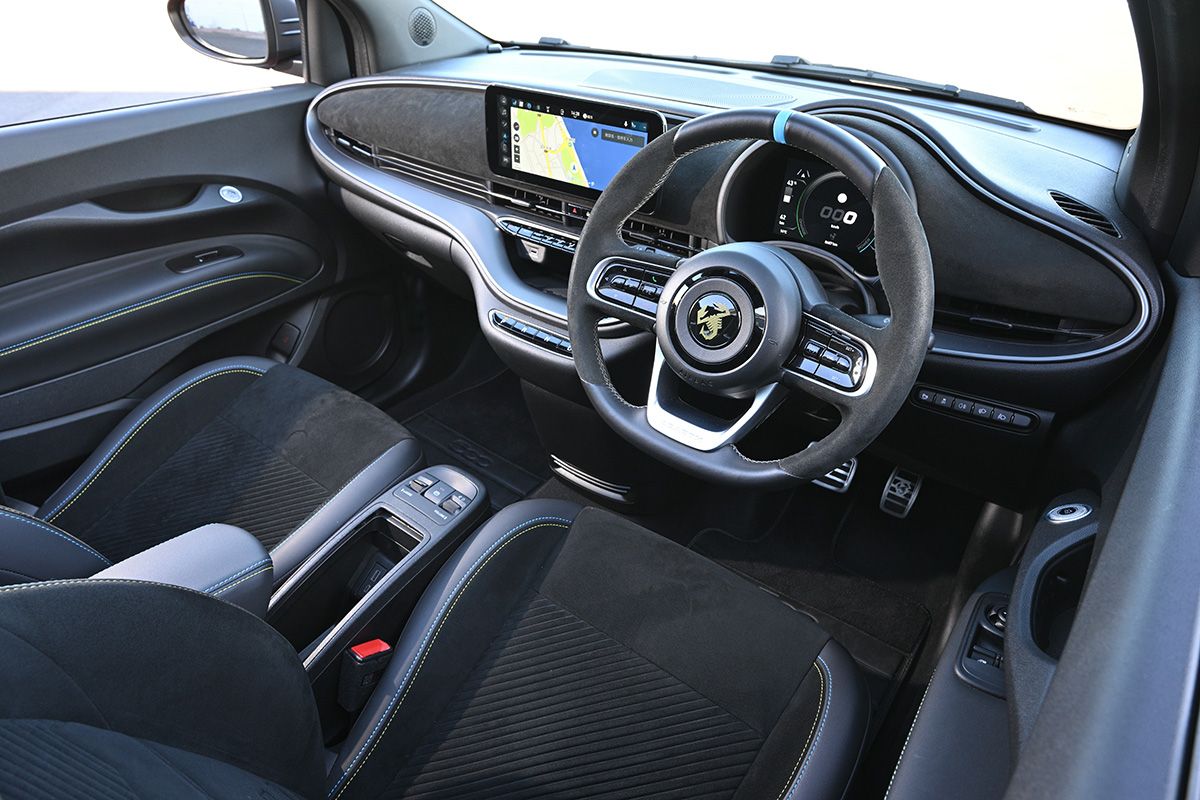 インテリアのデザインはフィアット500eに準ずるが、ステアリング・ホイール中央のサソリが個性を主張する。