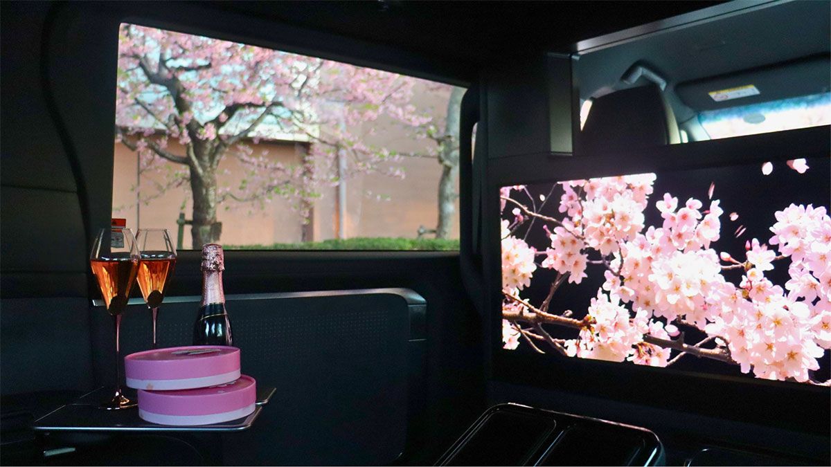 SAKURA RIDE PLANの車内では、ビールやシャンパン、お菓子やおつまみをオプションで提供するほか、大型スクリーンで桜をイメージした映像を放映。専用の乗車記念証も配布された。価格はオプションありが6.6万円、なしが5.6万円／1台。レギュラーメニューのTOKYOCHAUFFEUR SERVICEは一般時間貸し3時間5.4万円～、羽田空港～ホテル間片道4.5万円など。