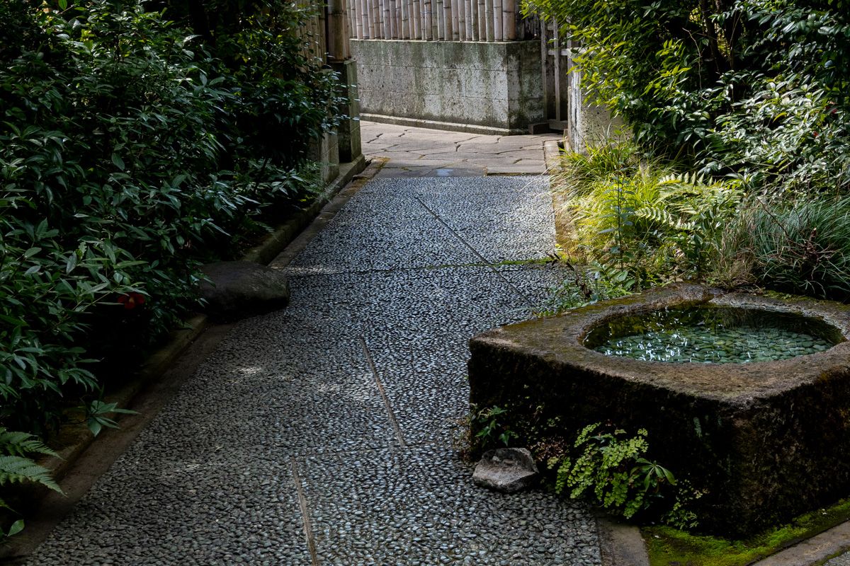 中門からアトリエに続く露地。埋め込まれた丸い石は、手前に行くに従って小さくなっている。途中にに蹲(つくばい)が設けてある。