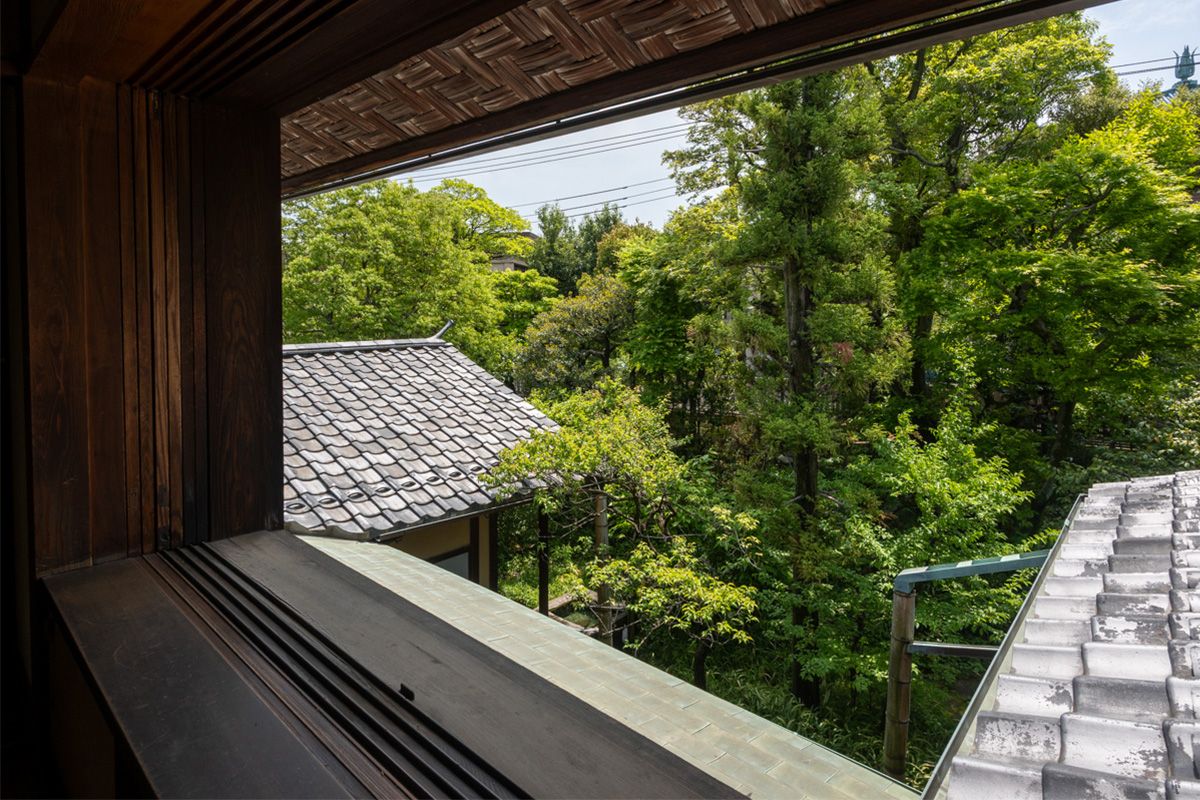 自邸2階の、龍子の寝室から見た南側の庭。窓枠は、装飾など何も存在しないクリーンな造形。木々の向こうに、龍子記念館の擬宝珠が見える。