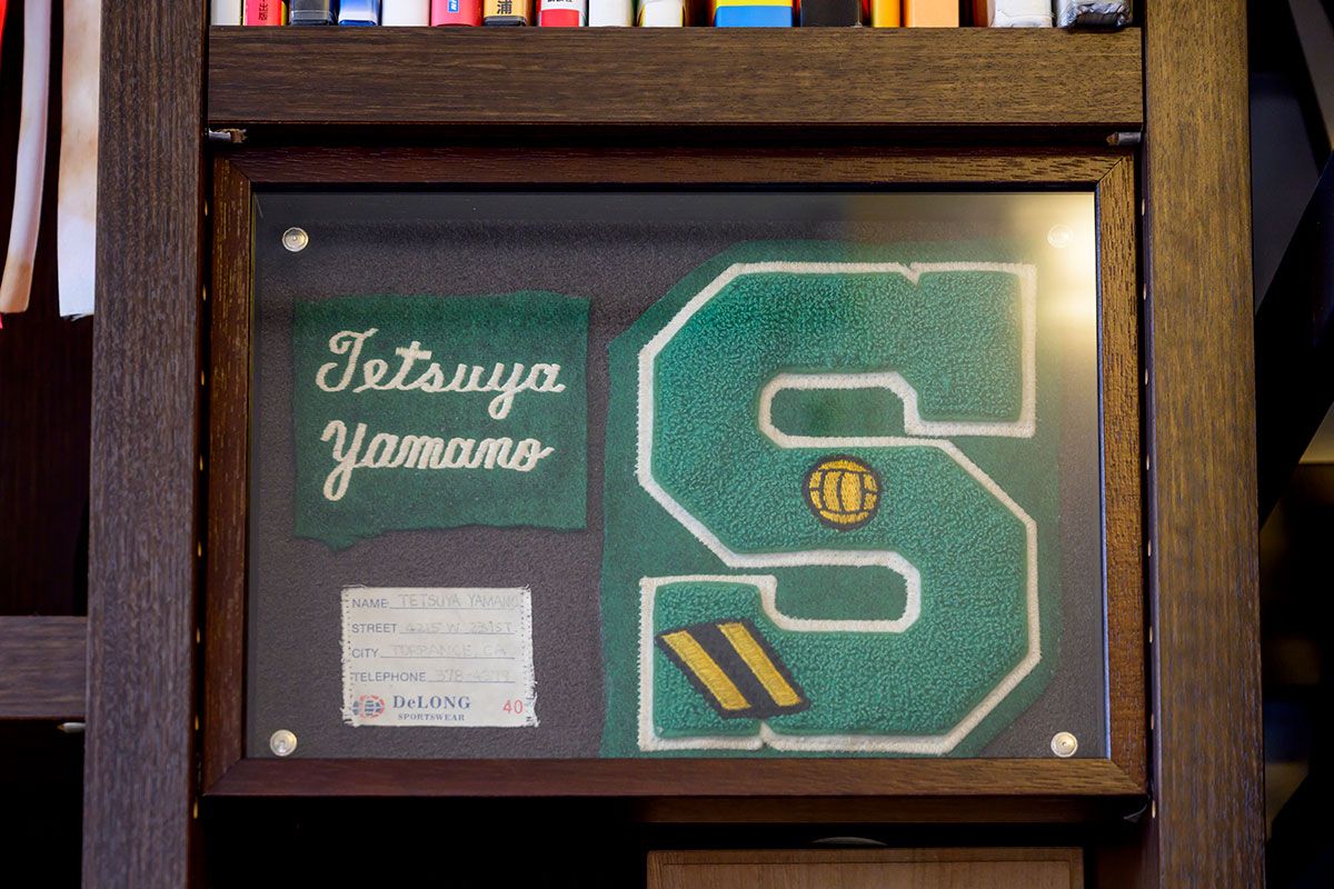 写真もハイスクール時代のもので、ネーム入りのお揃いのジャンパーから切り取ってディスプレーした。この頃の体験の多くが現在に続くチャンピオン山野のベースになっている。