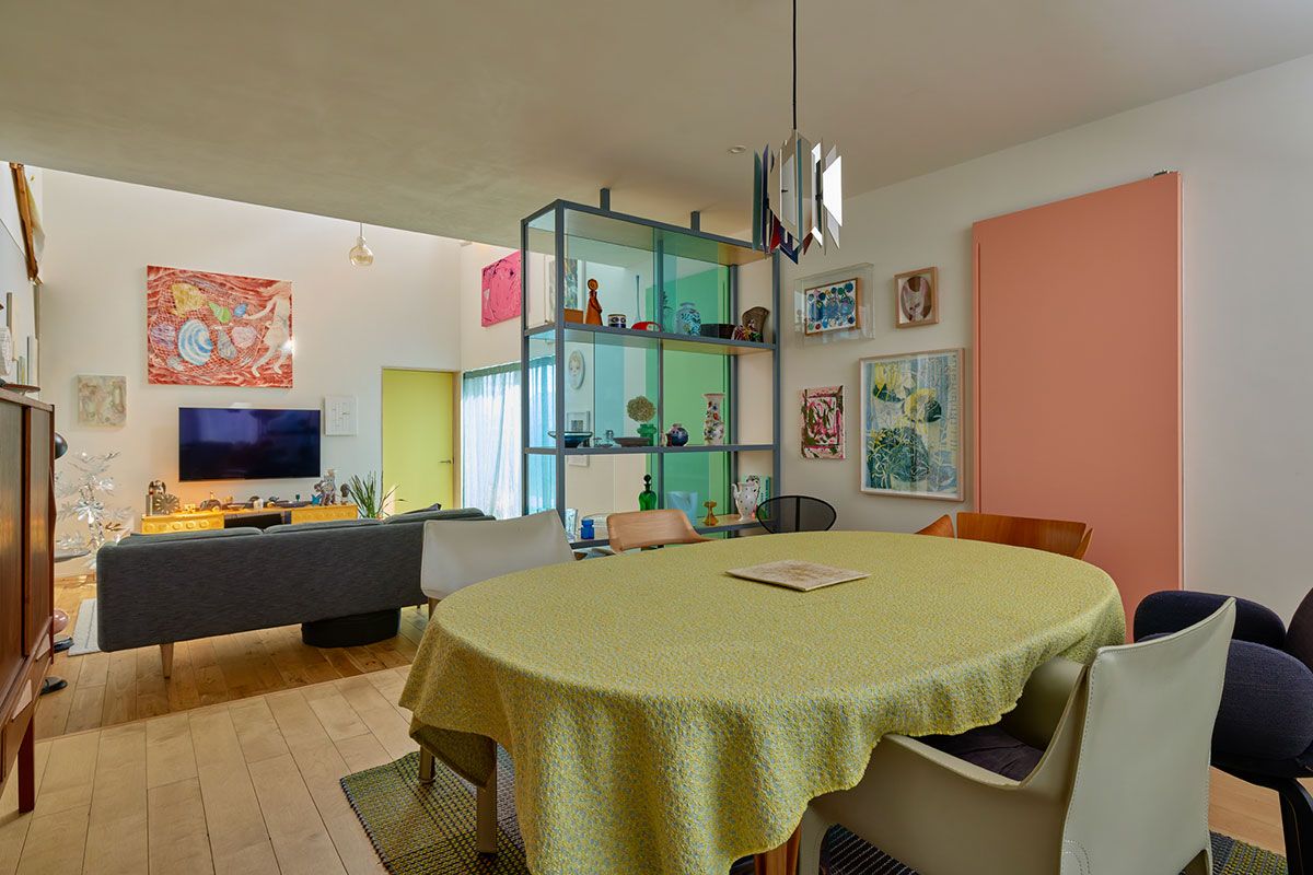 ダイニングルームと奥のリビングは、天井高を変えて変化を持たせた。両者を仕切る棚は、鬼頭さんの依頼で園田さんがデザインしたもの。扉の色も何種類かある。