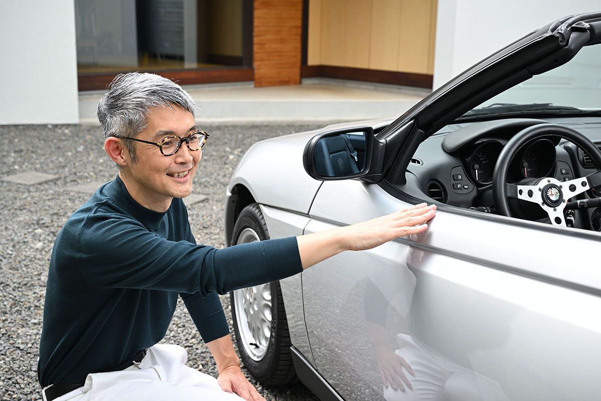 アルファ・ロメオ・スパイダーのデザインを建築家の目で説明する中佐さん。「家の設計も中から見たらどう見えるのか？　ということを考えています。運転席に座るとドアのこの上のラインがAピラーの手前でぐっと下がっていることがわかります。このおかげで開放感が増している。よく考えて作ってあるなあと」