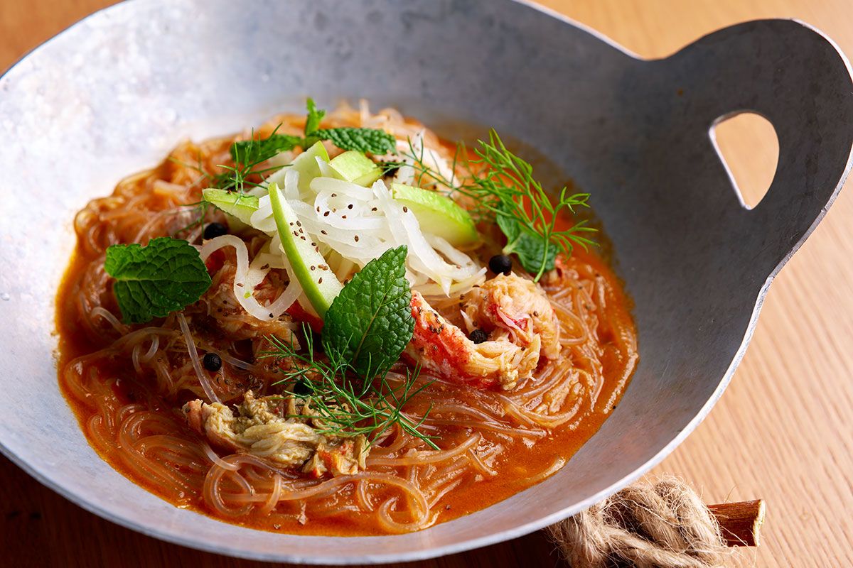 「オオズワイガニのプー オップ ウンセン」2640円。ズワイガニの旨味を吸った春雨の喉越しがよく、お酒によく合うタイ風の一品。カニミソと和えたカニ肉、大根とグラニースミス(りんご)のなますがトッピングされている。