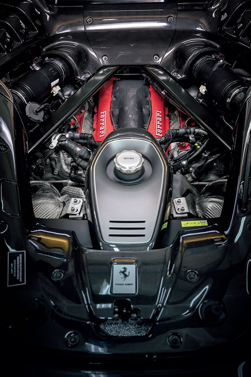 車名通り、赤く塗られたカムカバーを持つV8ツインターボは、ドライサンプ方式でミドシップの思い切り低い位置に置かれる。バンク両脇に配置されたターボチャージャーはまったく新しい大型化したものに換装されたが、チタン製ネジの採用などにより、重量増はほぼないという。